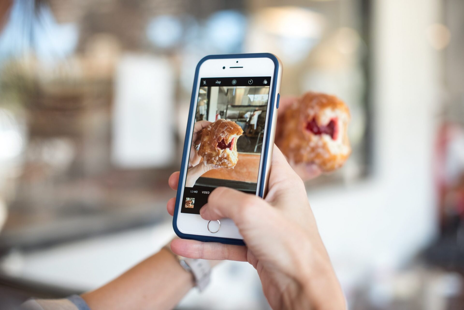 Mobile phone taking a photo of a donut